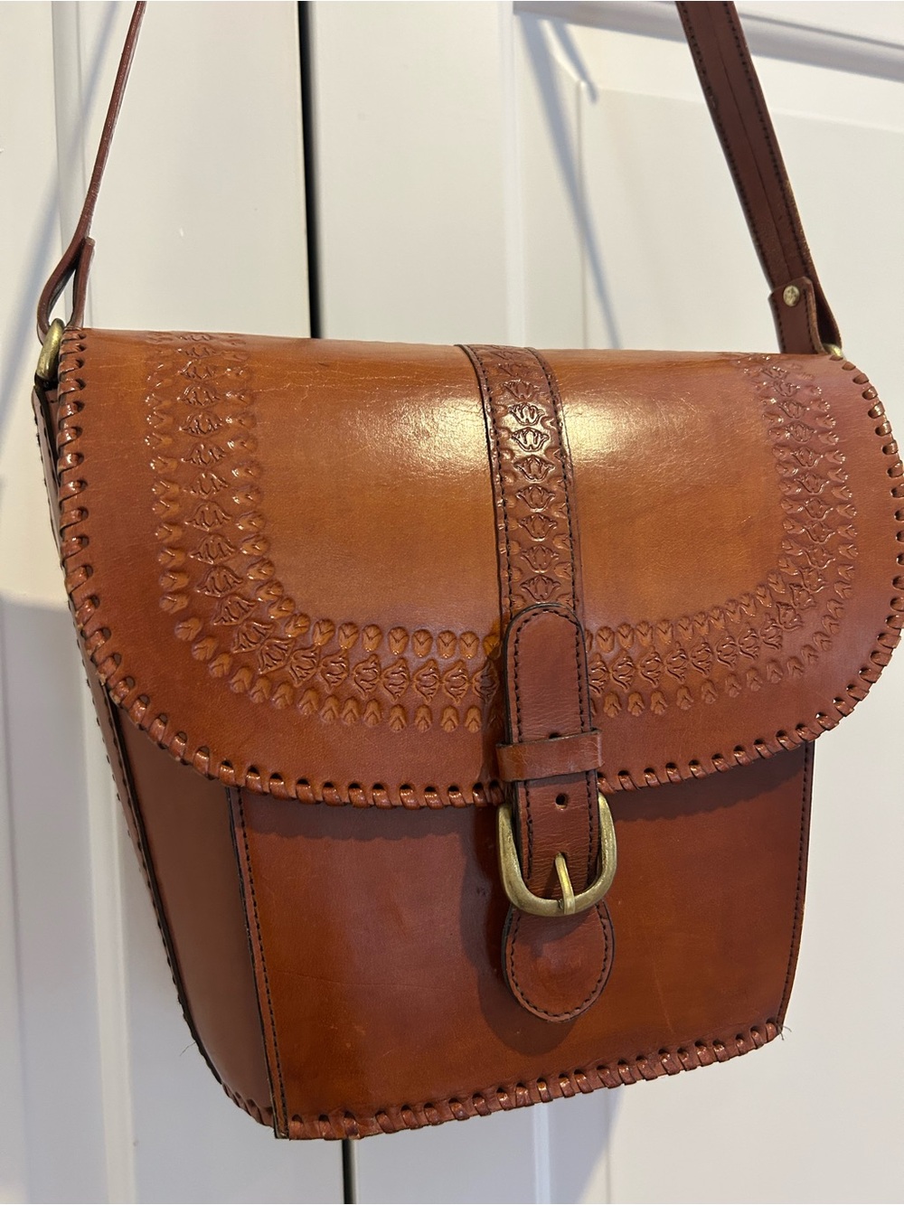 Brown leather bucket bag with brass hardware